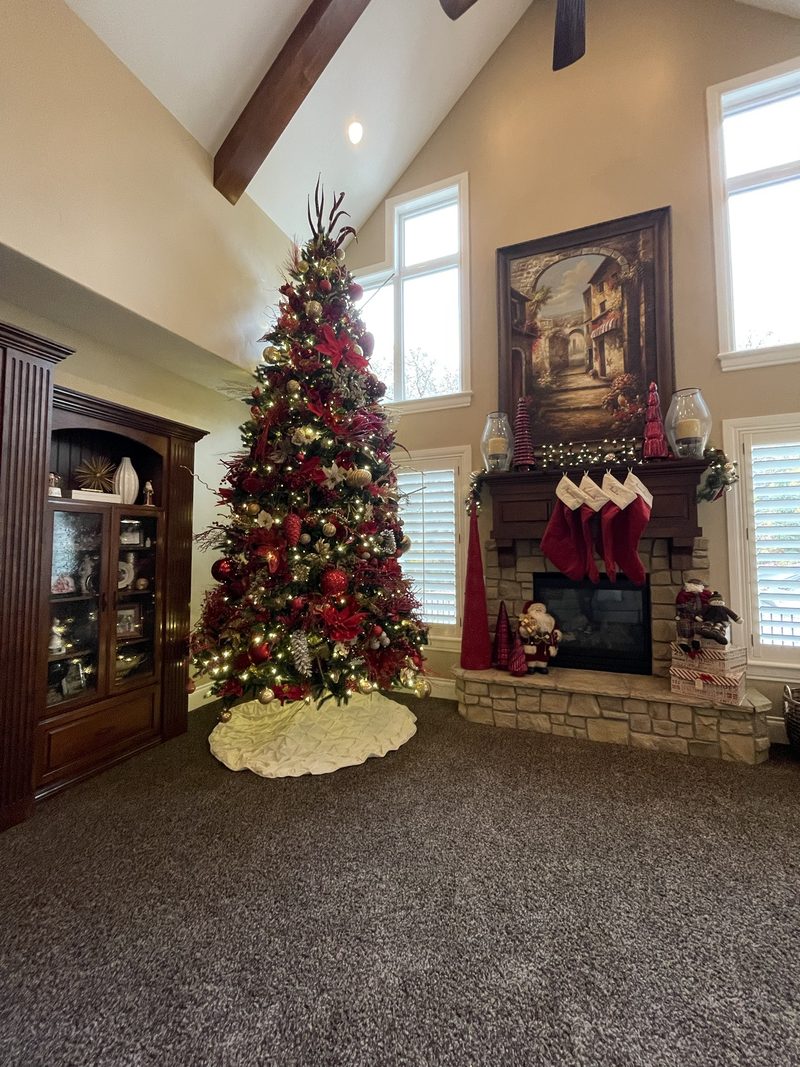 A decorated tree and mantel in a vaulted living room
